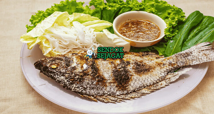 Pla Pao ikan gurame bakar garam daun pisang saus jeruk nipis di piring saji