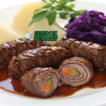 Rouladen daging gulung iris kuah wine dengan spaetzle di piring saji