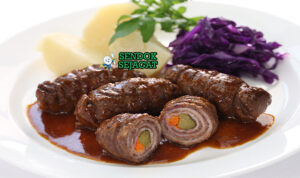 Rouladen daging gulung iris kuah wine dengan spaetzle di piring saji