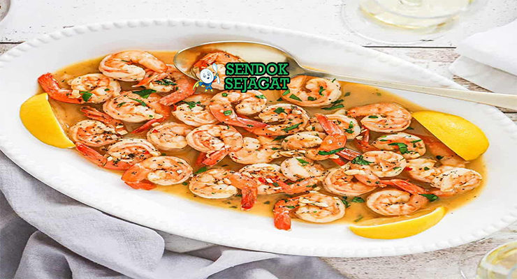 Shrimp Scampi udang besar saus mentega lemon parsley atas spaghetti di piring saji