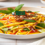 Thai Mango Salad mangga iris udang kering kacang cabai daun mint di mangkuk saji