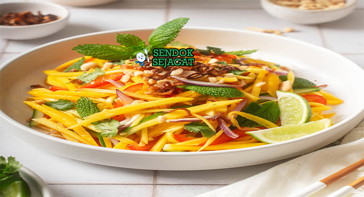 Thai Mango Salad mangga iris udang kering kacang cabai daun mint di mangkuk saji