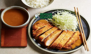Tonkatsu iris tebal panko garing saus kol di piring saji