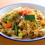Yakisoba mie tumis sayur daging tabur aonori katsuobushi di mangkuk saji