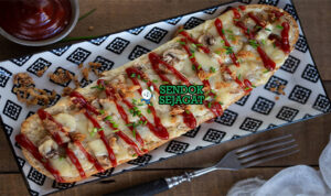 Zapiekanka Golden Bubbly Khas Kraków Polandia Zapiekanka baguette panjang keju gouda meleleh jamur bawang goreng saus mayo di atas kertas