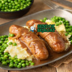 Bangers and Mash sosis garing kentang mash creamy onion gravy peterseli mushy peas di piring pub
