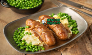 Bangers and Mash Pub Style Khas Inggris Bangers and Mash sosis garing kentang mash creamy onion gravy peterseli mushy peas di piring pub