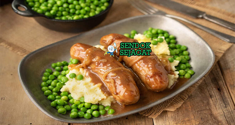 Bangers and Mash sosis garing kentang mash creamy onion gravy peterseli mushy peas di piring pub