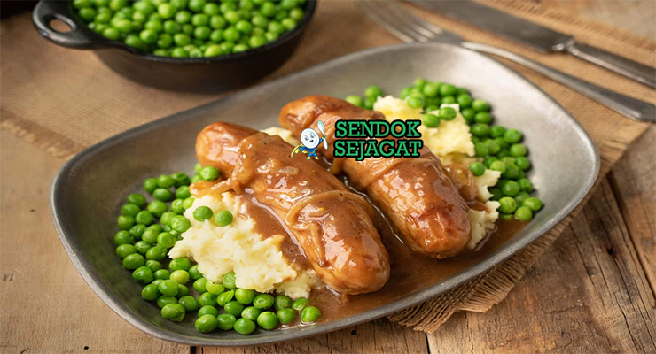 Bangers and Mash sosis garing kentang mash creamy onion gravy peterseli mushy peas di piring pub
