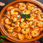 Gambas al Ajillo udang merah mengkilap minyak zaitun bawang putih iris cabe guindilla peterseli di cazuela tanah liat