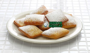 Mandazi Garing Manis Khas Mombasa Afrika Timur Mandazi segitiga golden gembung tinggi tumpuk panas tabur gula chai masala di samping