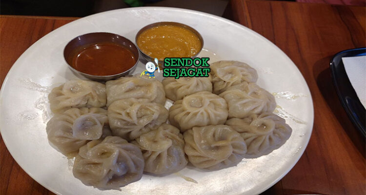 Momo dumpling kukus isi ayam achar tomat pedas sesame timur piring kayu Nepal