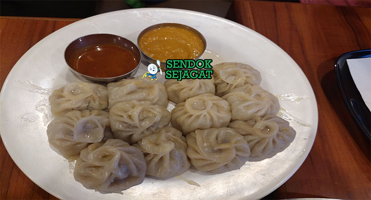 Momo dumpling kukus isi ayam achar tomat pedas sesame timur piring kayu Nepal