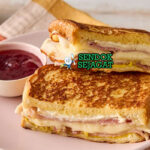 Monte Cristo Sandwich goreng golden ham turkey Swiss cheese powdered sugar raspberry jam potong diagonal