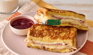 Monte Cristo Sandwich Crispy Sweet-Savory Khas Amerika Monte Cristo Sandwich goreng golden ham turkey Swiss cheese powdered sugar raspberry jam potong diagonal