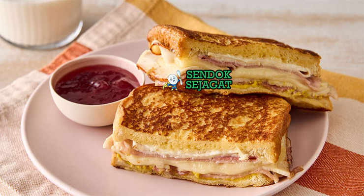 Monte Cristo Sandwich goreng golden ham turkey Swiss cheese powdered sugar raspberry jam potong diagonal