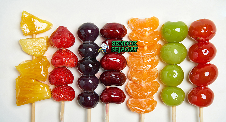 Tanghulu tusuk strawberry hawthorn anggur karamel bening mengkilap kristal merah di gelas tinggi