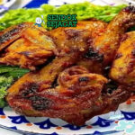 Ayam bakar madu khas Bandung dengan kulit mengkilap manis, nasi hangat, lalapan timun kemangi, sambal terasi, piring makan Sunda