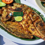 Ikan bakar Jimbaran khas Bali kulit mengkilap madu kecap, nasi hangat, lalapan timun kemangi, sambal terasi, piring pantai Jimbaran