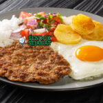 Silpancho nasi daging sapi goreng tepung roti telur mata sapi saus tomat kentang peterseli piring Cochabamba Bolivia