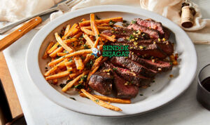 Steak Frites Gurih Renyah Khas Prancis Steak Frites steak ribeye medium rare kentang goreng renyah saus persilade salad vinaigrette baguette piring Prancis