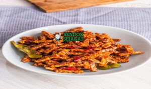 Tempe orek khas Jawa Tengah, tempe kering manis gurih cokelat tua kecap cabe bawang, disajikan dengan nasi putih sambal terasi lalapan timun kemangi