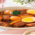 Thịt Kho Tàu khas Vietnam, daging ba chỉ rebus telur warna cokelat caramel nước dừa, disajikan panas dengan nasi trắng dưa chua rau sống, hidangan keluarga Saigon