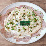 Vitello Tonnato irisan daging sapi dingin saus tonnato caper peterseli lemon baguette piring Italia