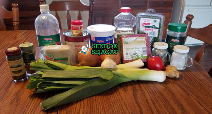 Bahan-bahan resep Ashak termasuk tepung terigu, daun bawang, tomat, kacang merah, yogurt, rempah, dan bawang siap dibuat