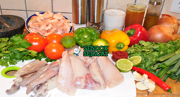 Bahan segar resep caldeirada Portugal: campuran ikan laut segar, udang besar, kerang hijau, cumi, kentang potong, tomat merah, bawang bombay, bawang putih, saffron, paprika bubuk, minyak zaitun di atas meja dapur kayu