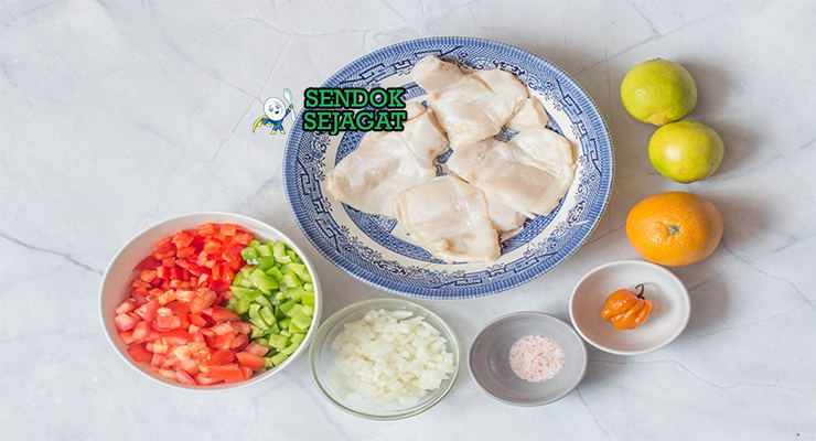 Bahan segar resep conch salad Bahama: daging conch bersih, tomat merah, bawang merah, paprika, cabai scotch bonnet, ketumbar segar, jeruk nipis, minyak zaitun di atas talenan dapur kayu