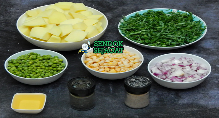 Bahan segar resep mukimo Kenya: kentang potong dadu, kacang hijau kering rendam, jagung manis pipil, bawang bombay, bawang putih, mentega, garam di atas meja dapur kayu sederhana