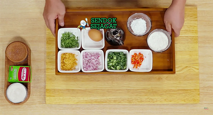 Bahan-bahan resep perkedel tahu termasuk tahu putih, bawang merah putih, daun bawang, tepung, dan telur siap digoreng