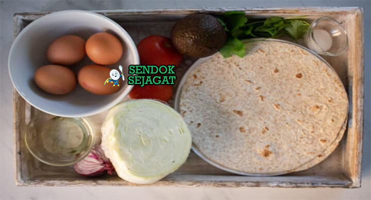 Bahan-bahan segar resep Rolex Uganda: lembar chapati, telur ayam, kol iris tipis, bawang bombay cincang, tomat dadu, daun ketumbar, dan bumbu garam lada