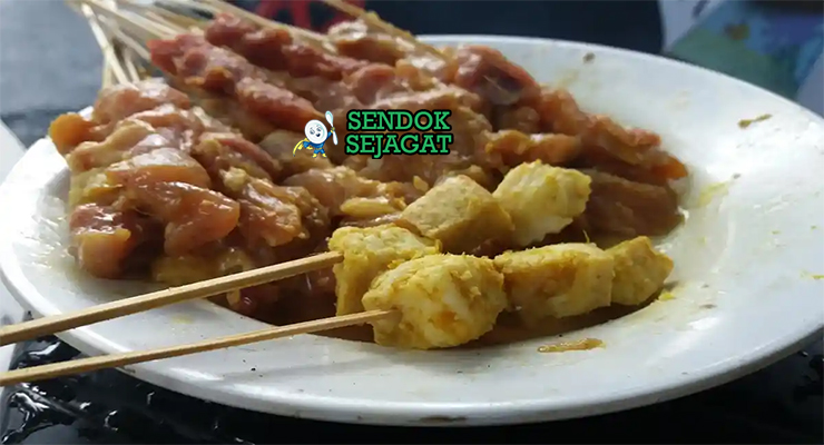 Bahan-bahan resep Sate Susu Sapi termasuk daging ayam, santan kental, bawang, lengkuas, daun jeruk, serai, dan rempah siap dibakar