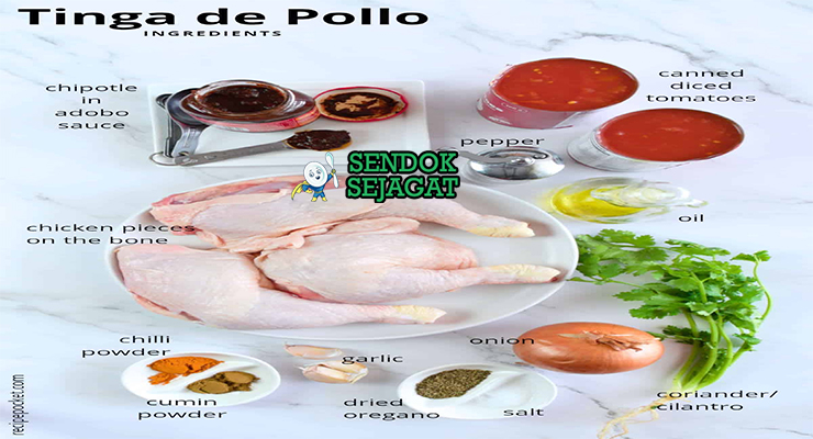 Bahan segar resep tinga de pollo Meksiko: dada ayam, tomat matang, chipotle dalam adobo, bawang bombay, bawang putih, oregano, jinten, gula merah, minyak zaitun di atas meja dapur kayu