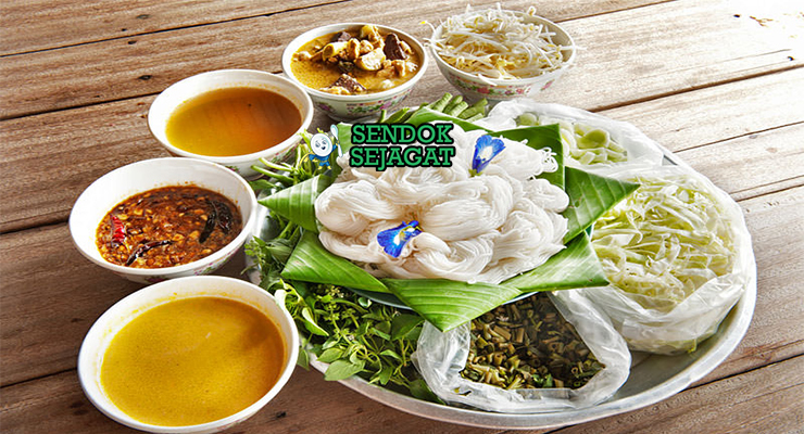 Bahan-bahan segar untuk membuat resep Nom Banh Chok: fillet ikan nila, santan kental, serai, kunyit, daun jeruk purut, dan sayuran topping