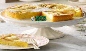 Apfelkuchen Siap Sajikan Hangat Potongan Apfelkuchen khas Jerman dengan apel segar tenggelam di kue lembut, taburan kayu manis, tampak hangat dan menggugah selera