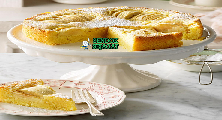 Potongan Apfelkuchen khas Jerman dengan apel segar tenggelam di kue lembut, taburan kayu manis, tampak hangat dan menggugah selera