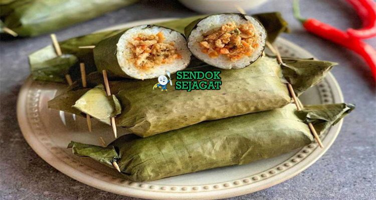 Arem-arem khas Jawa Tengah siap saji: lontong ketan pulen dibungkus daun pisang hijau, potong memperlihatkan isian ayam suwir bumbu kental manis pedas, terlihat gurih hangat dengan uap mengepul