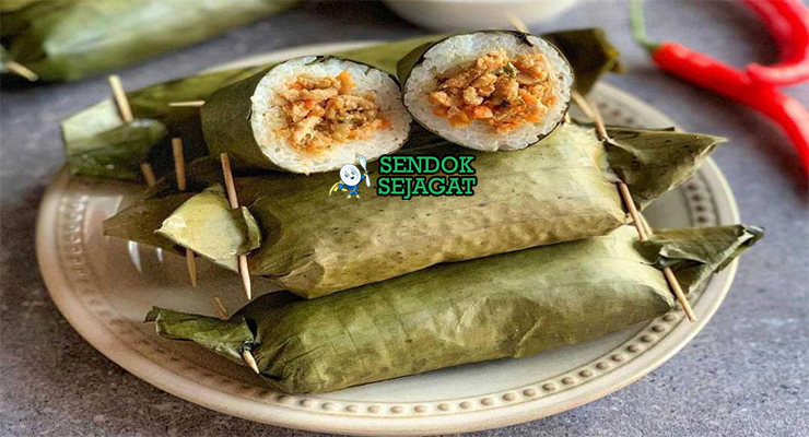 Arem-arem khas Jawa Tengah siap saji: lontong ketan pulen dibungkus daun pisang hijau, potong memperlihatkan isian ayam suwir bumbu kental manis pedas, terlihat gurih hangat dengan uap mengepul