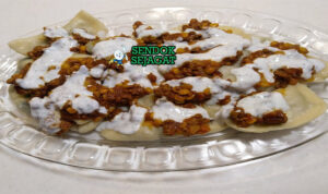 Piring Ashak khas Afghanistan dengan dumpling kukus lembut, saus tomat kacang kental, yogurt dingin, mint kering, tampak gurih segar menggugah selera