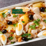 Bacalhau à Gomes de Sá Panas dari Oven dengan Kentang Keemasan dan Zaitun Bacalhau à Gomes de Sá khas Portugal siap saji: loyang berisi ikan kod asin suwir empuk, kentang iris keemasan, bawang karamel, telur rebus potong, zaitun hitam, dan peterseli tabur, terlihat gurih hangat dengan uap mengepul