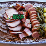 Piring besar Berner Platte khas Swiss dengan irisan daging asap, sosis, sauerkraut, kentang, wortel, tampak gurih hangat menggugah selera