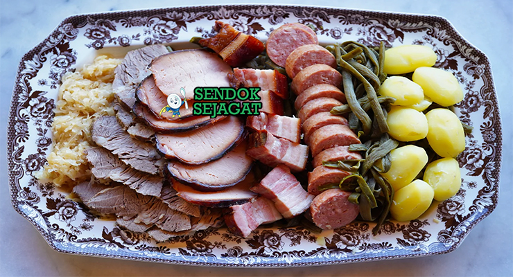 Piring besar Berner Platte khas Swiss dengan irisan daging asap, sosis, sauerkraut, kentang, wortel, tampak gurih hangat menggugah selera