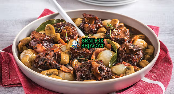 Potongan braised kangaroo tail khas Australia yang empuk terlepas dari tulang, disiram kuah kental gurih berwarna cokelat tua, disajikan dengan kentang tumbuk dan sayur hijau segar