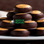 Tumpukan Buckeyes khas Amerika dengan selai kacang creamy terlihat di atas, lapisan cokelat renyah, tampak manis dan menggoda