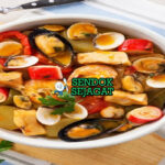Caldeirada khas Portugal siap saji: panci besar berisi sup ikan dan seafood—potongan ikan putih empuk, udang besar, kerang terbuka, cumi cincin, kentang lembut, dalam kuah tomat kuning saffron wangi, tabur peterseli segar, terlihat gurih hangat dengan uap mengepul