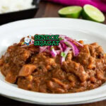 Mangkuk carapulcra khas Peru berisi sup kental kentang kering papa seca, potongan daging babi empuk, kuah merah kecokelatan dari ají panca dan kacang tanah, disajikan dengan nasi putih