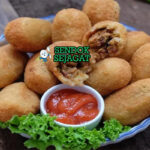 Combro khas Jawa Barat siap saji: gorengan singkong parut renyah keemasan, isi oncom pedas daun jeruk terlihat menggoda dengan uap panas dan sambal kecap